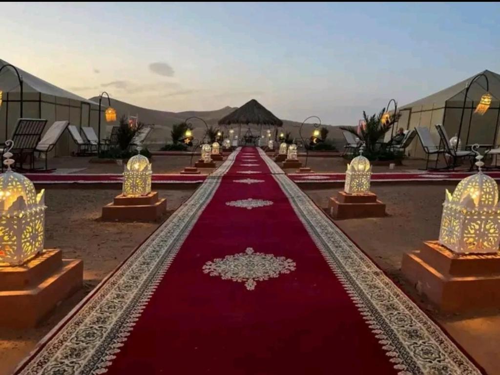 a red carpeted aisle in a compound with mountains in the background at Galaxy stars camp in Hassilabied