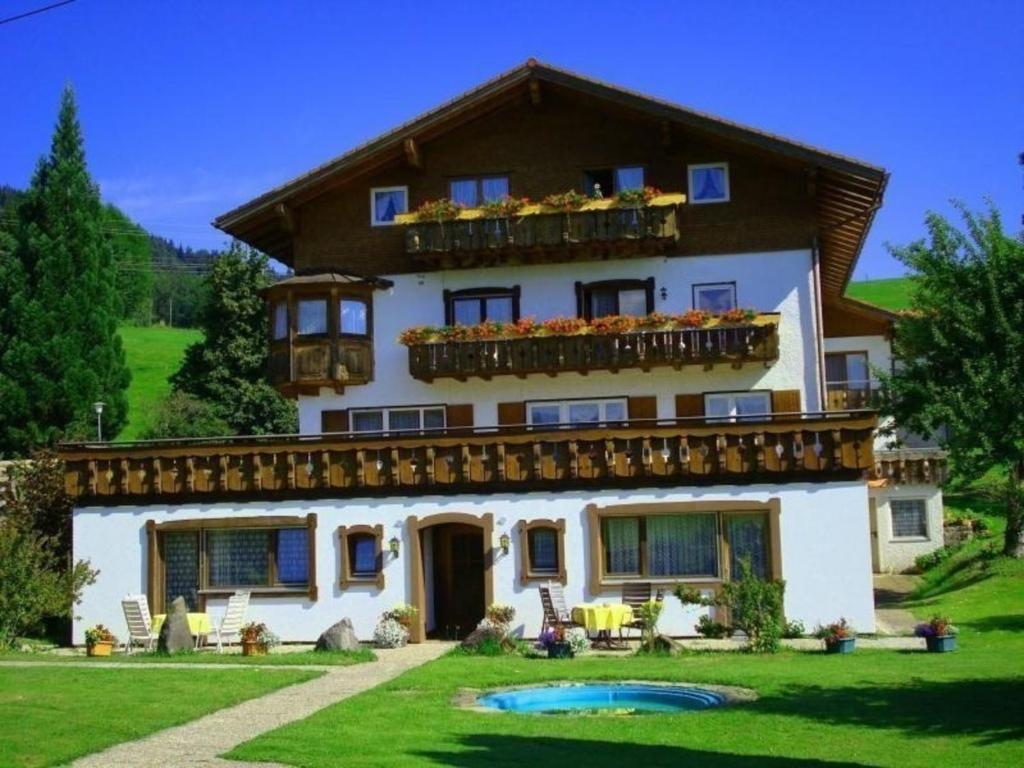 ein großes weißes Haus mit einem großen Hof in der Unterkunft Einmalige Panorama-Bergsicht in die Allgäuer Alpen in ruhiger Einzellage in Ofterschwang
