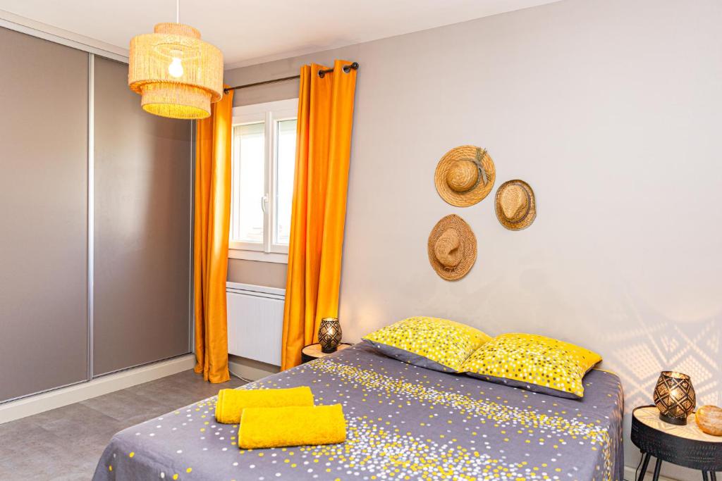 um quarto com uma cama com almofadas amarelas e uma janela em Les Tournesols em Saint-Martin-de-Crau