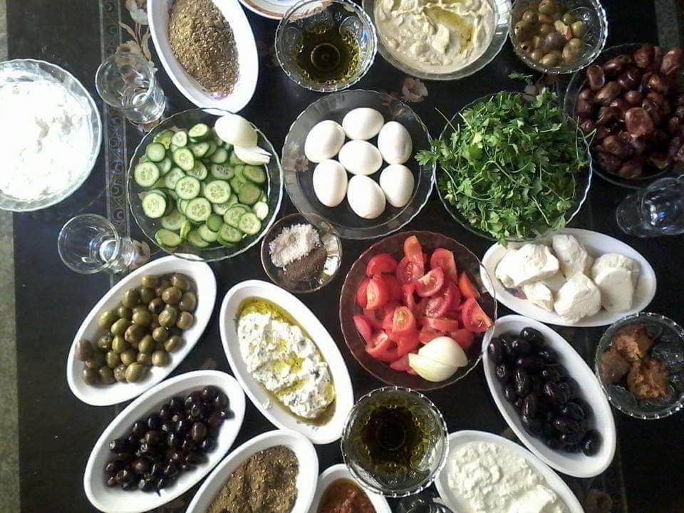 una mesa cubierta con cuencos de diferentes tipos de alimentos en Beit alkaram, en Kerak