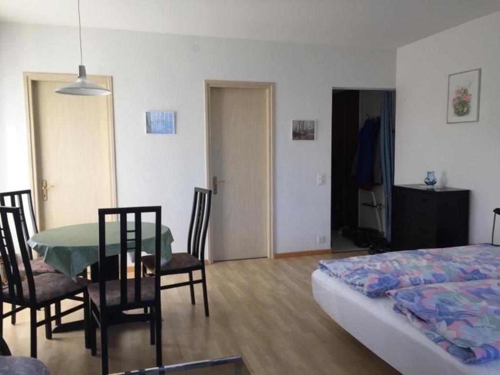 Habitación con cama, mesa y sillas. en Appartamento Doris en Locarno