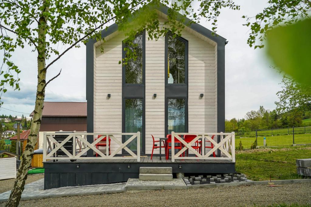 una casa pequeña con una mesa roja en el porche en Ptaszkova PrzyStań 2, en Ptaszkowa