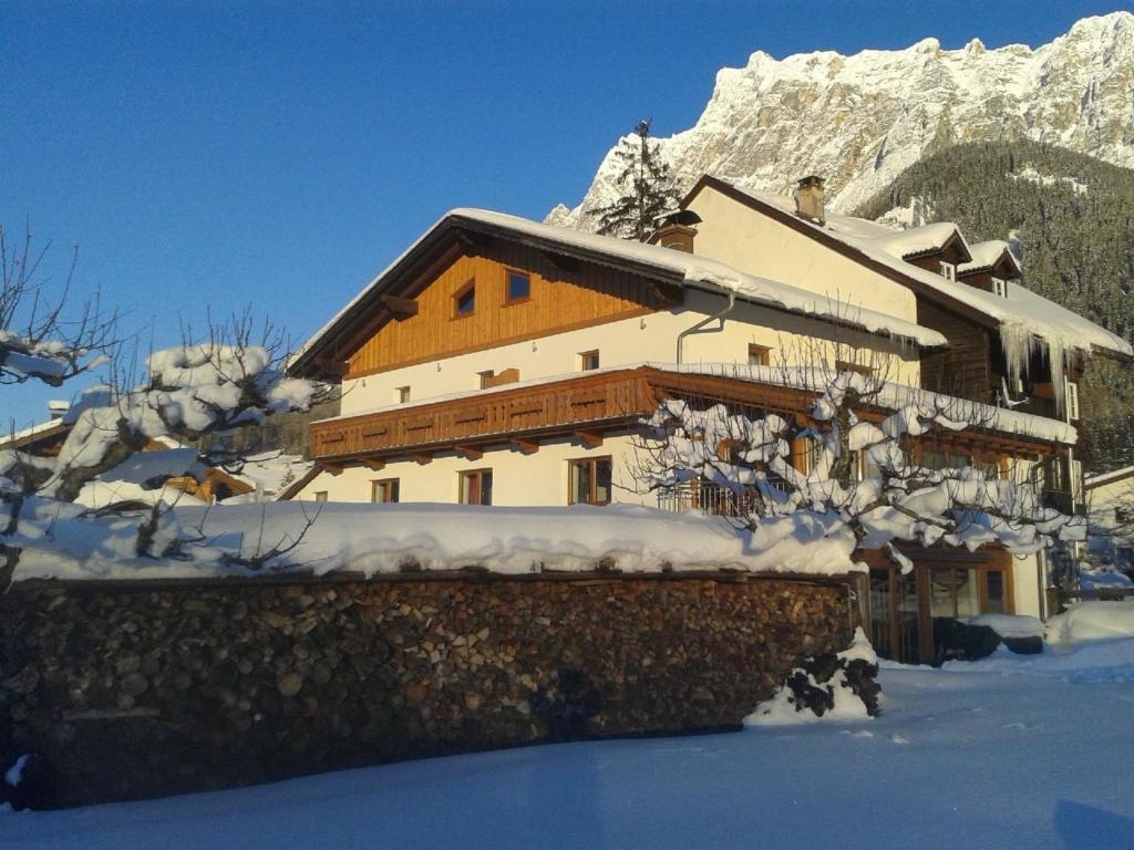 a large building with snow on it in the mountains at Ehrwalder Sonnenhof in Ehrwald