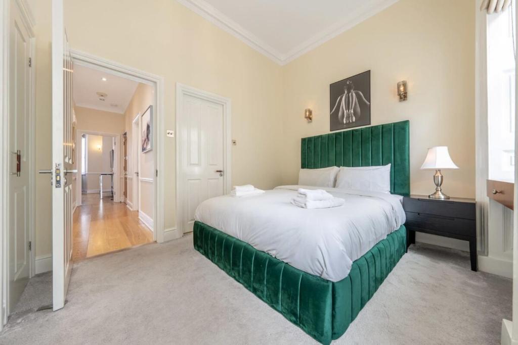 a bedroom with a large green bed in a room at Exclusive 2-Bedroom Apartment in London