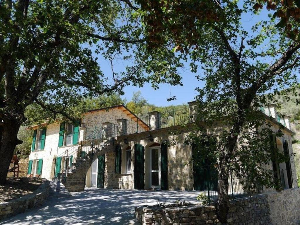 TesticoにあるFerienhaus in Stellanello mit Terrasse, Grill und Gartenの目の前に木々が植えられた古い石造りの家