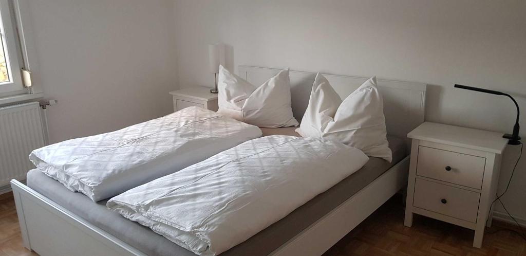 ein Bett mit weißer Bettwäsche und Kissen darauf in der Unterkunft Ferienwohnung Borse in Langenlois