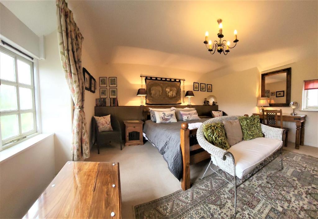 een slaapkamer met een bed, een stoel en een tafel bij escape the ordinary - Piddle Inn the Home private self cater holiday in Dorchester