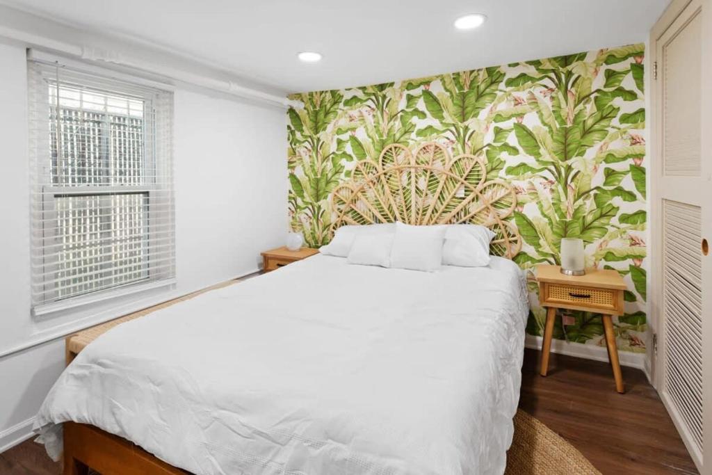 um quarto com uma cama branca e um papel de parede floral em Quiet Convenient 2-Family House - Tropical Design em Atlantic City