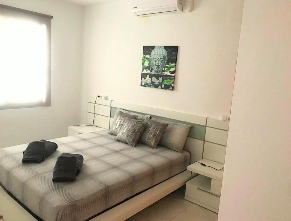een slaapkamer met een groot bed met 2 kussens bij Apartamento Marlayo in Cala Blanca