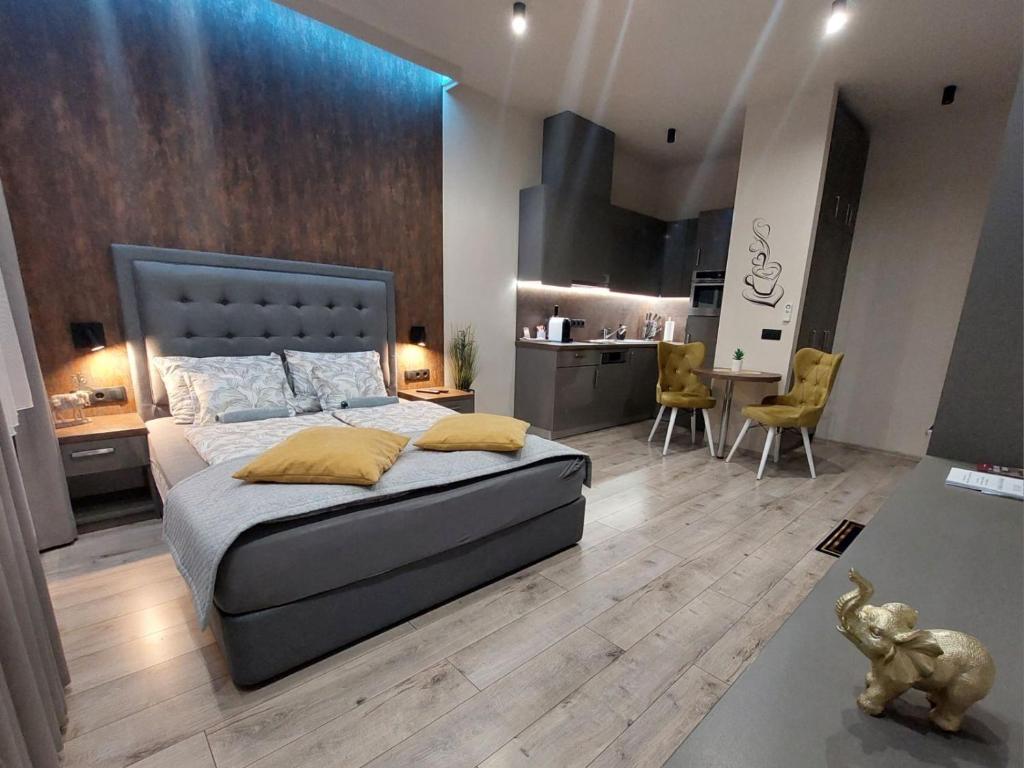 a bedroom with a large bed and a kitchen at Silver Dawn Apartments in Szeged