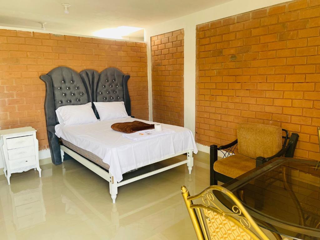 a bedroom with a bed and a chair in it at HOTEL REAL BERNAL in Chincha Alta