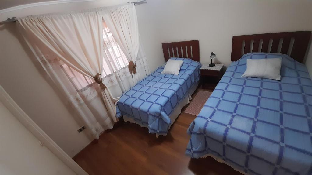 2 camas individuales en una habitación con ventana en Casa Peñuelas, en Coquimbo