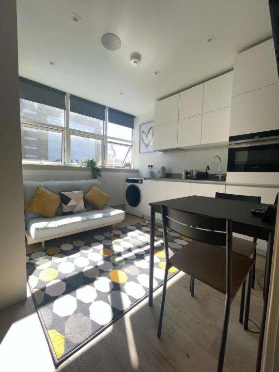 a kitchen with a couch and a table in a room at Inviting Studio Apartment - Central Croydon London in London