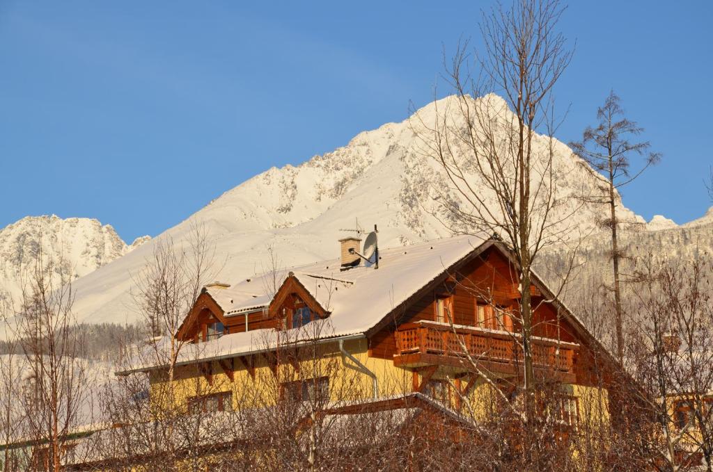 domek w górach ze śniegiem na dachu w obiekcie Privat Iva Smokovec w mieście Nový Smokovec