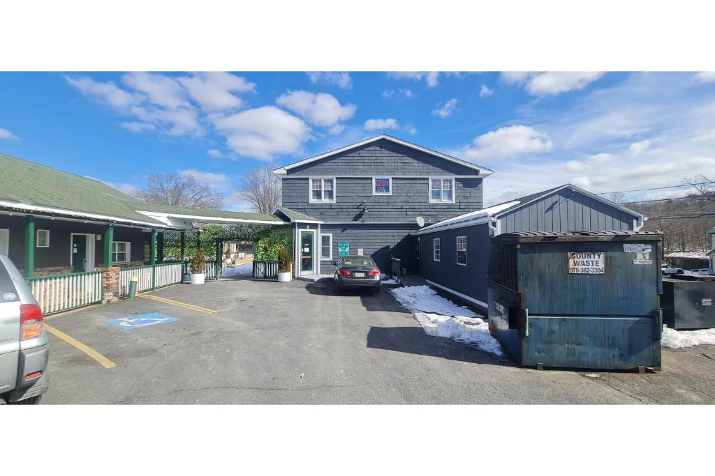 a house with a car parked in a parking lot at Werry's Cottages Motel & Pub by OYO East Stroudsburg Poconos in East Stroudsburg