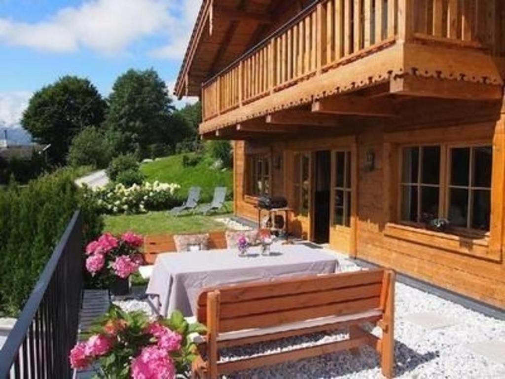 ein Holzhaus mit einem Tisch und einer Bank in der Unterkunft Nettes Ferienhaus in Gaisbichl mit Terrasse und Garten in Niedernsill