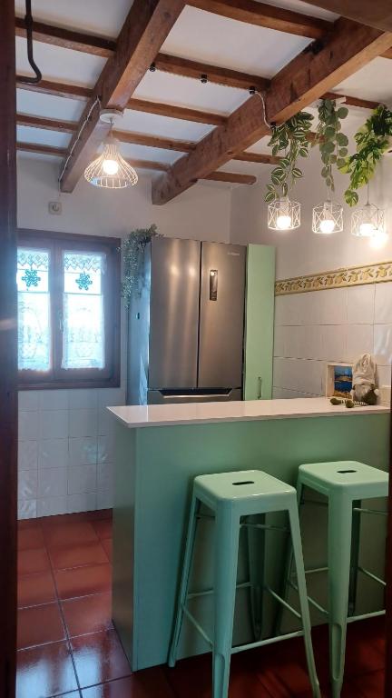 a kitchen with two stools at a kitchen counter at Casa en Ferreries in Ferreries