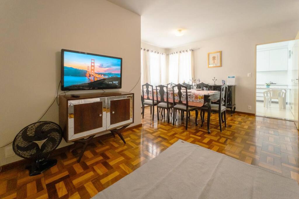 a living room with a television and a dining table at Espaçoso e Confortável Próximo da UEM - EL08 in Maringá
