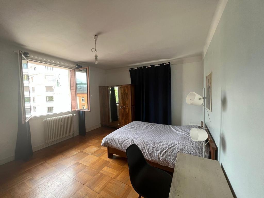 1 dormitorio con cama, escritorio y ventana en Welcome en Chambéry