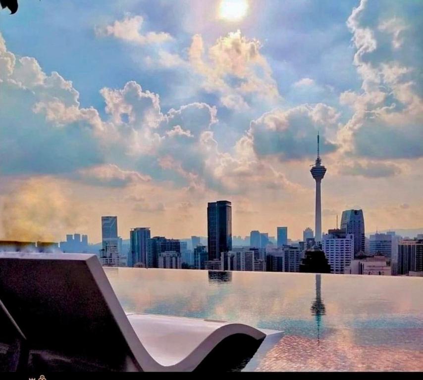 een zwembad met uitzicht op de skyline van de stad bij KL SUITES AT AXON RESIDENCE KLCC in Kuala Lumpur