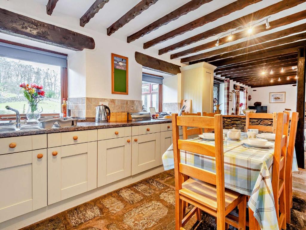 een keuken met witte kasten en een tafel met stoelen bij 3 Bed in Bampton 92037 in Bampton