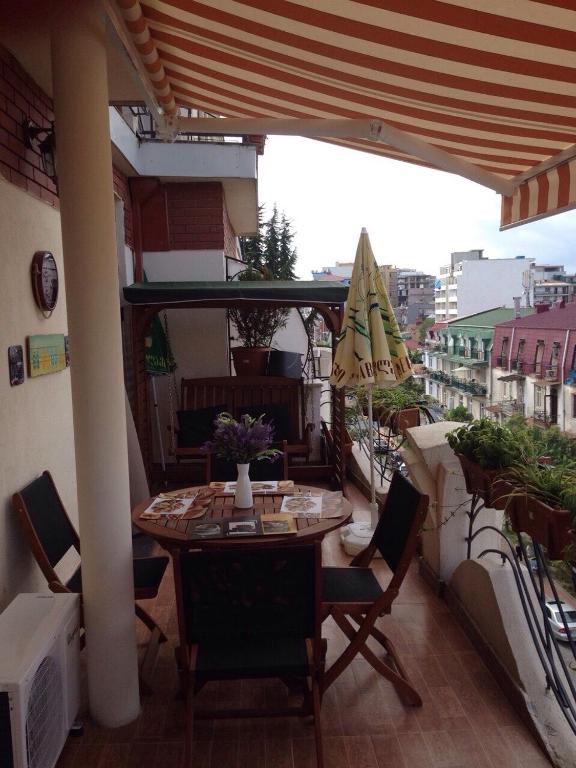 a patio with a table and chairs on a balcony at Apartment with Summer Terrace in Batumi