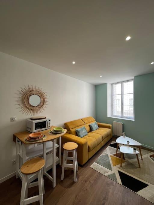 un salon avec un canapé et une table dans l'établissement La maison castelpontine studio 2, à Pont-du-Château