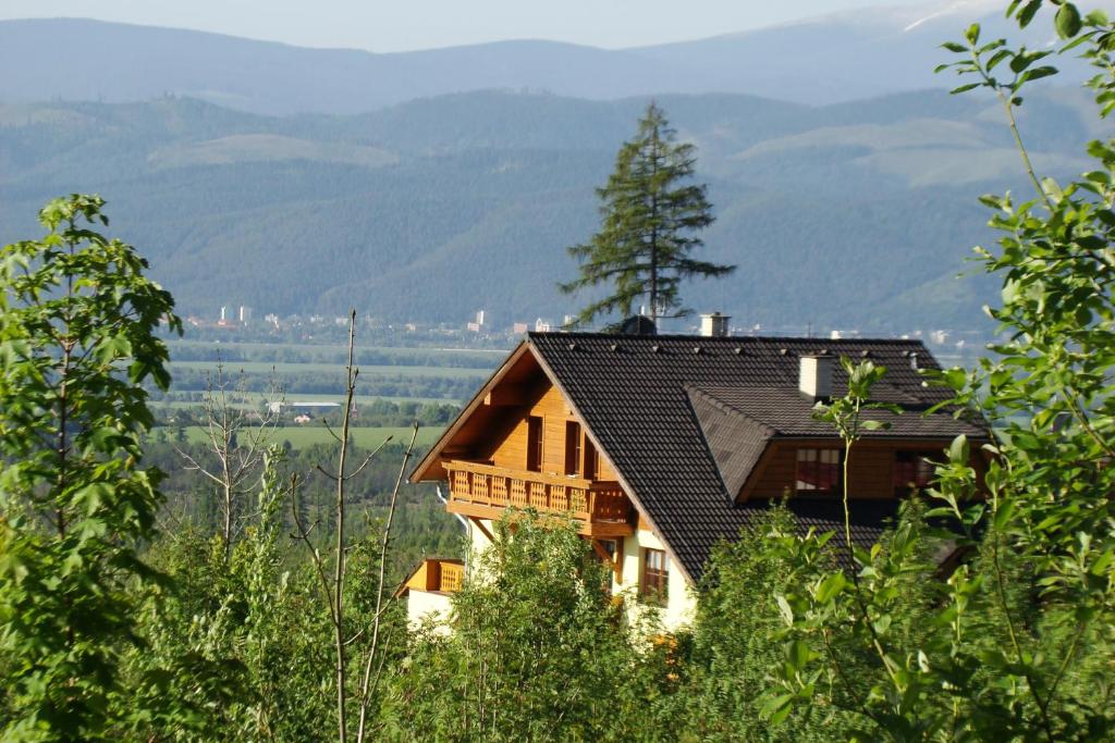 a house on a hill with mountains in the background at Privat Iva Smokovec in Vysoke Tatry - Novy Smokovec