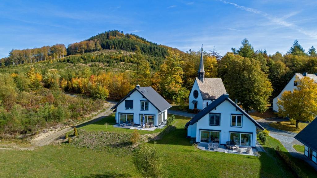 an aerial view of a house with a church at Ferienhäuser Hoher Knochen in Winterberg