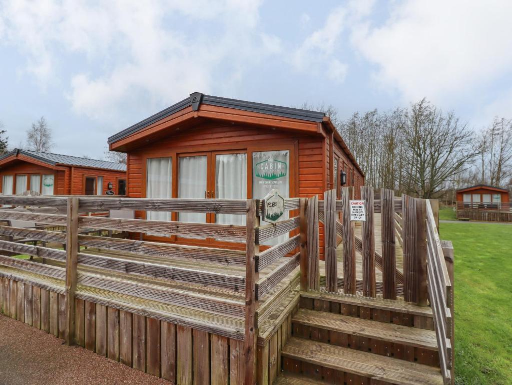a wooden cabin with a fence in front of it at Pegasus in Morpeth