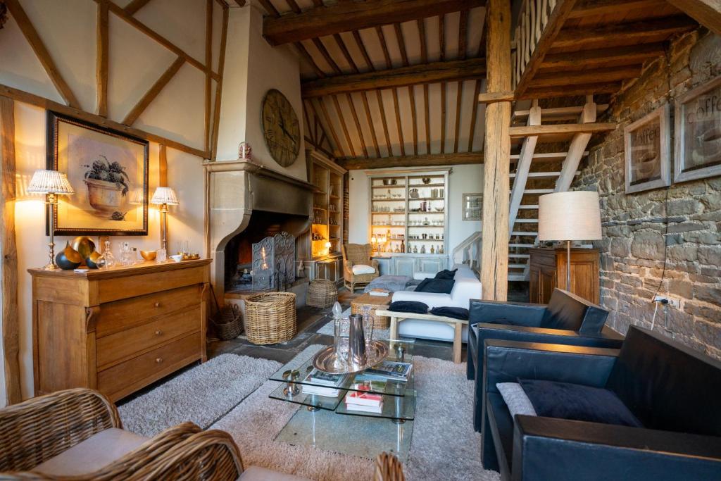 ein Wohnzimmer mit einem Sofa und einem Kamin in der Unterkunft Gîte " Les Demoiselles d'Ellemelle " in Ouffet