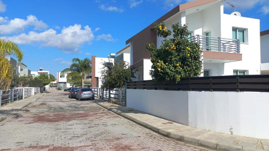 una casa con alberi di arancio sul lato di una strada di 3 bedroom Villa in Pyla a Larnaka