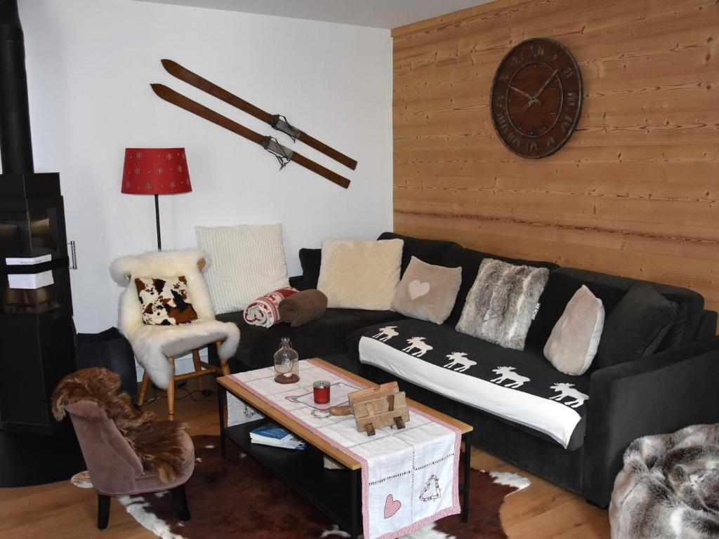 un salon avec un canapé noir et une table dans l'établissement Appartement cosy 3 pièces - 6 personnes, balcon, centre, proche commerces et téléphérique - FR-1-464-12, à Pralognan-la-Vanoise