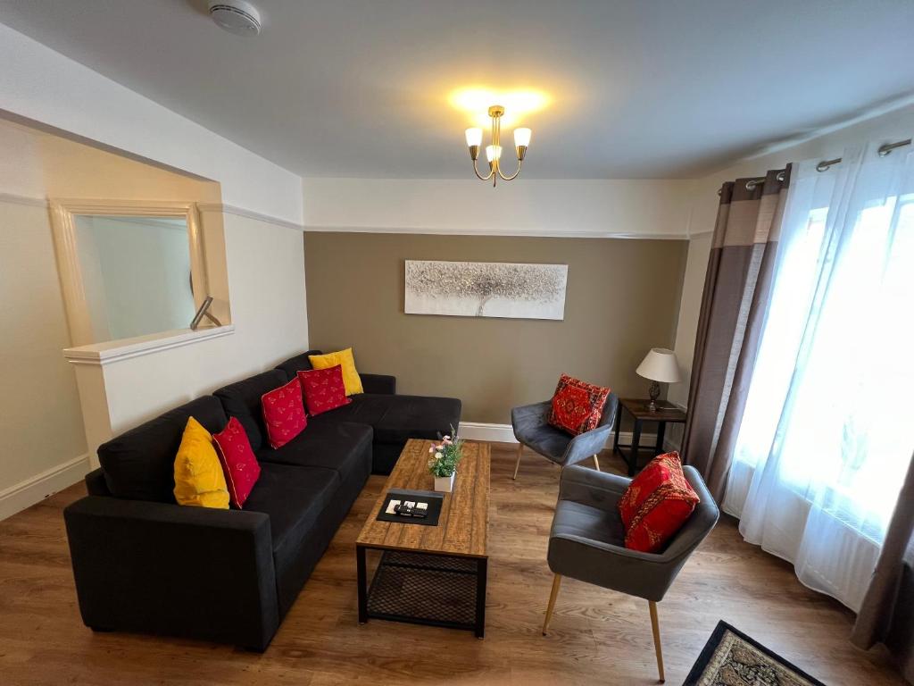 a living room with a black couch and colorful pillows at Glastonbury Town Centre - Large 2 Bedroom Apt With Balcony in Glastonbury
