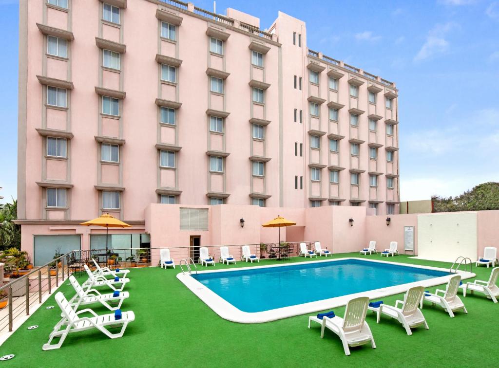 un hotel con piscina y sillas y un edificio en Hotel Veracruz Centro Histórico, en Veracruz