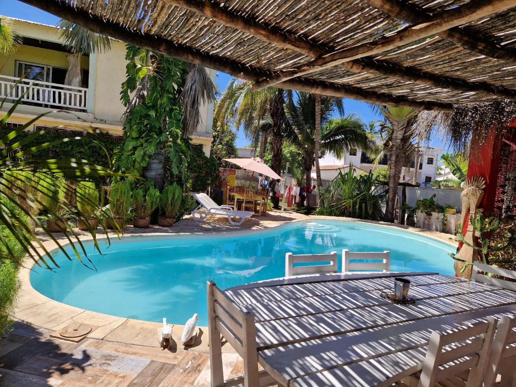 a large blue swimming pool with a wooden deck at la Maison rouge in Toliara