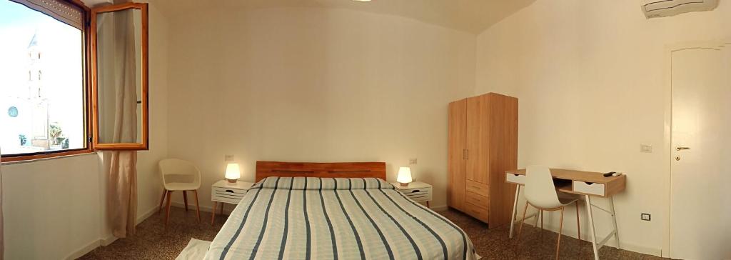 カリアリにあるCinghiale Biancoのベッドルーム1室(ベッド1台、デスク、椅子2脚付)