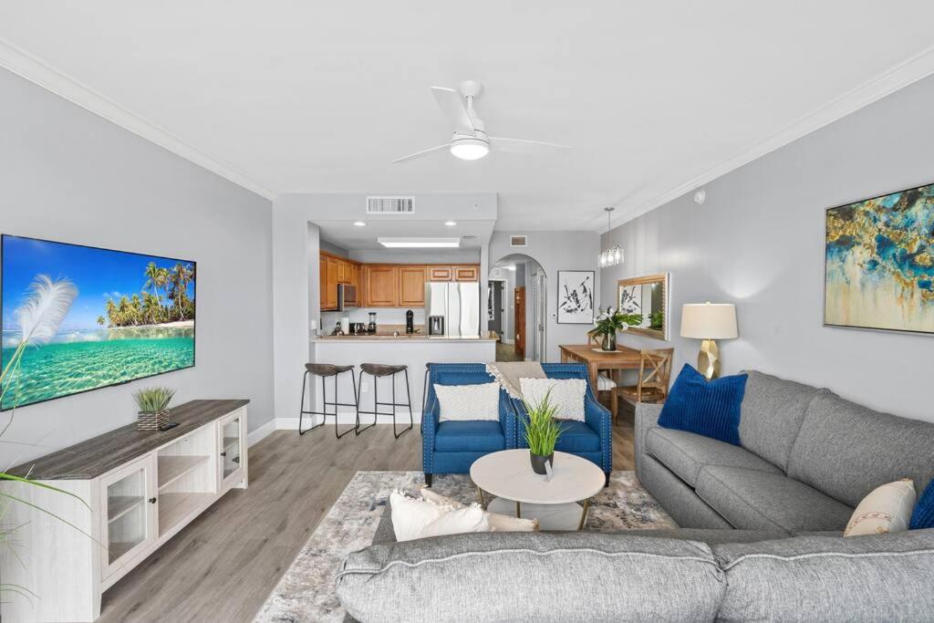 a living room with a couch and a kitchen at Scenic View Condo Near Disney in Orlando