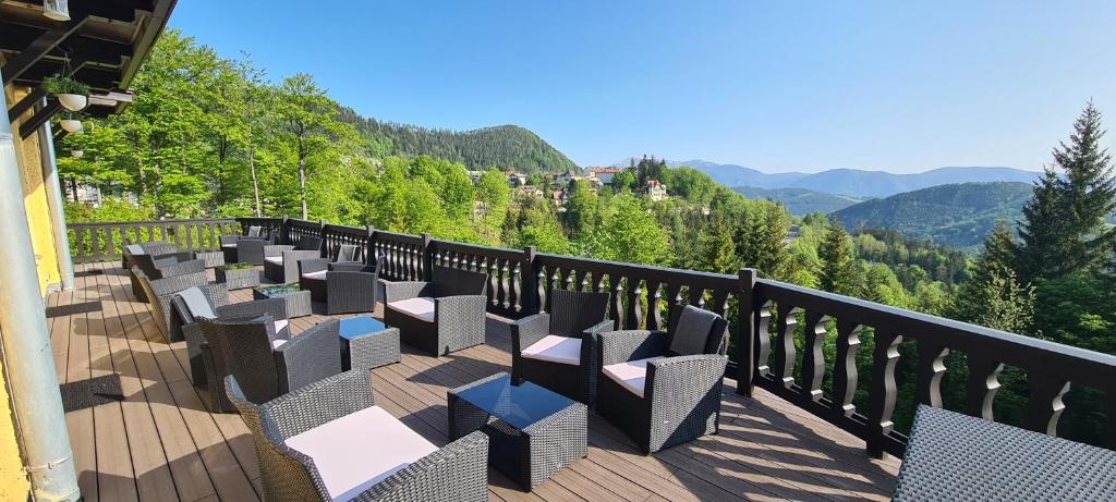 uma varanda com cadeiras e vista para as montanhas em Kurhotel Renona Rehabilitation em Semmering