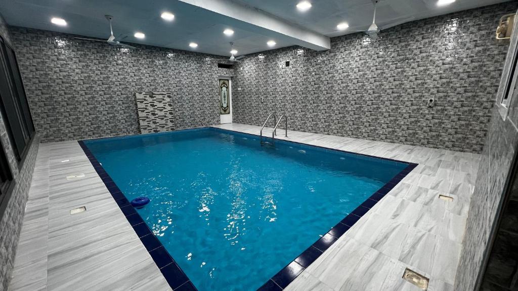 una piscina in una stanza con muro di mattoni di استراحة روضة الوادي a Nizwa