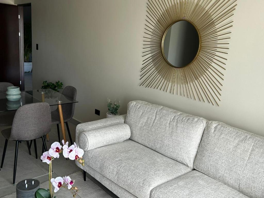 uma sala de estar com um sofá e um espelho em Tropical Sunshine known as Amaranto em Alajuela