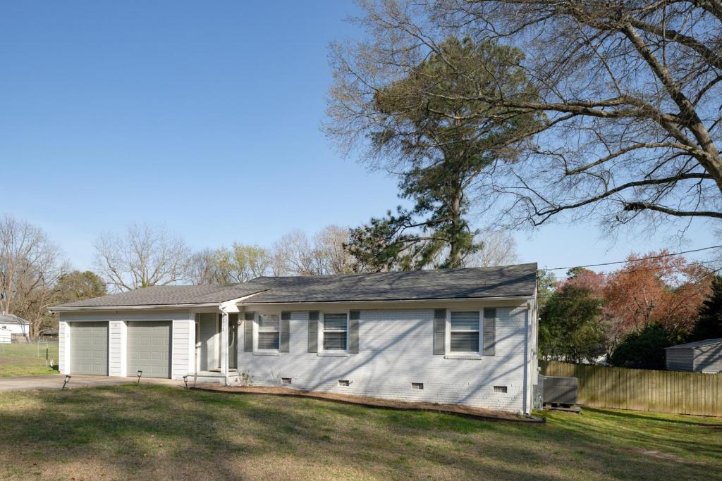 a small white house in a yard at 3Bed City Ranch near DTR in Raleigh