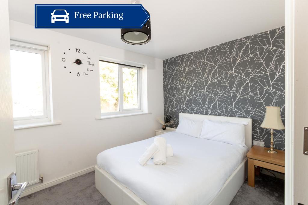 een slaapkamer met een wit bed met een wit knuffeldier erop bij Spacious 3BR House with Garden & Free Parking in Manchester