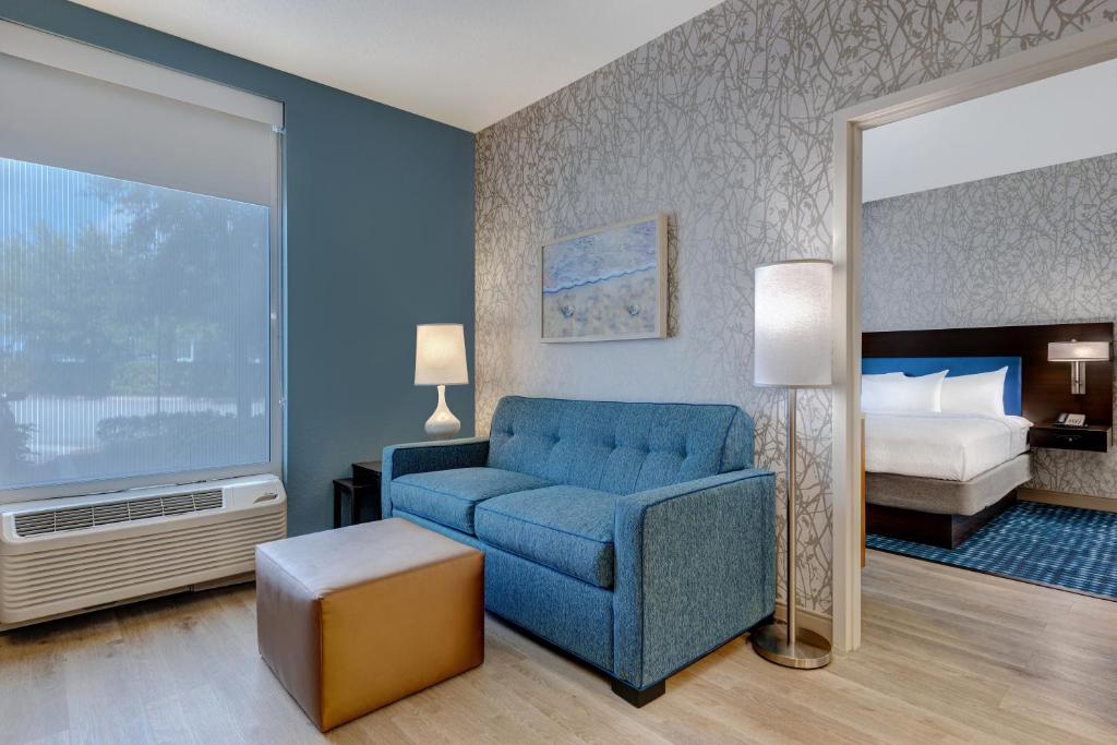 sala de estar con sofá azul y cama en Home2 Suites By Hilton Austin East Side en Austin