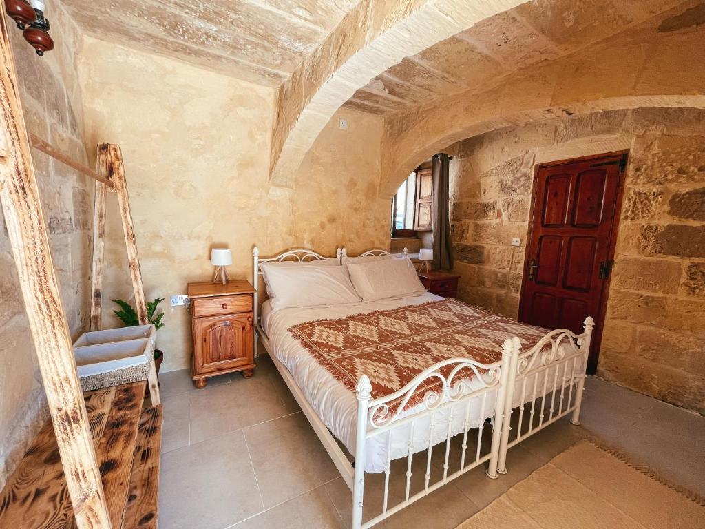 a bedroom with a bed and a chair in a room at Soluna Boutique Guesthouse in Għasri