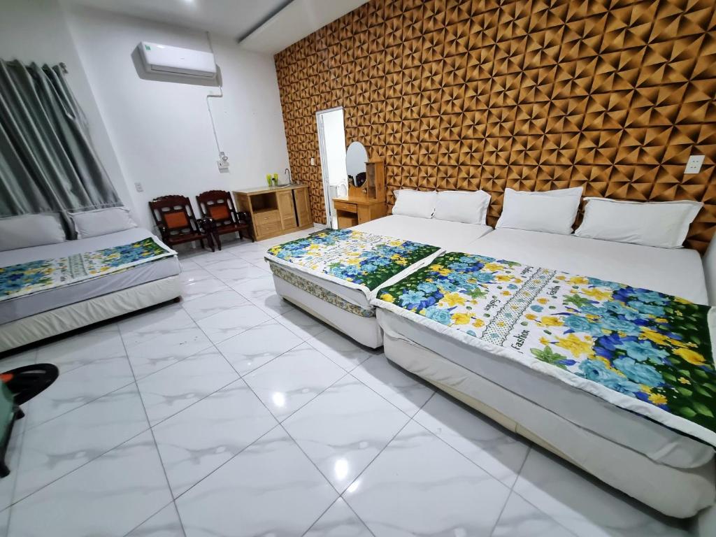 a bedroom with two beds and a brick wall at Mai Thảo in Vung Tau