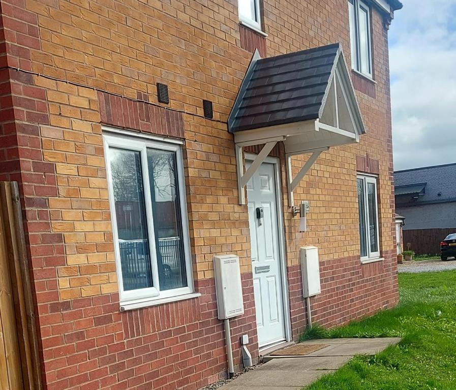 a brick house with a white door and a roof at Inviting 3-Bed House in Bolton in Bolton