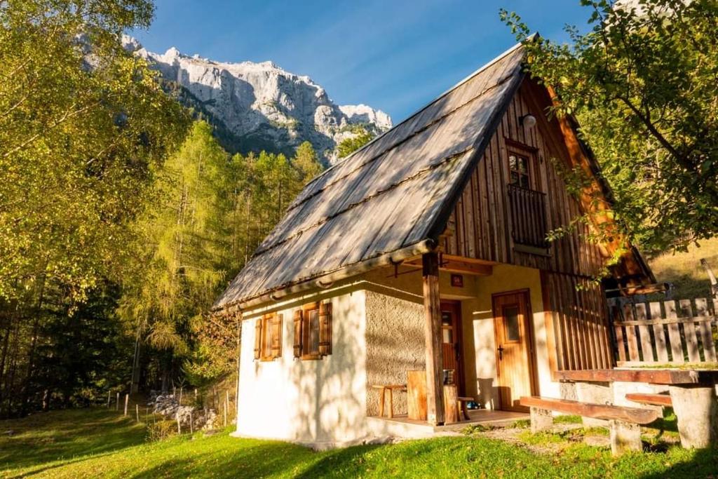 a small house in the mountains with a bench at Cottages Kravanja in Trenta