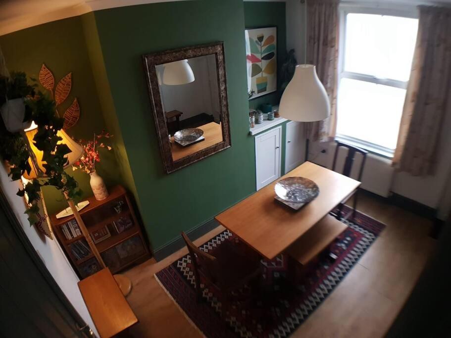 een woonkamer met een tafel en een spiegel bij The Cosy Home in Burton. Sleeps 5. Fast Wi-fi in Burton upon Trent