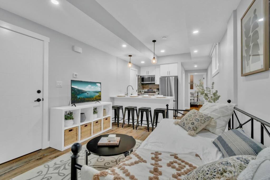a living room with a couch and a kitchen at Stylish Suite-NearWEM-4 Bed-Central in Edmonton